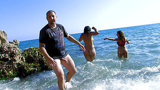 Busty girl in threesome on the beach