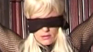Mature Dominatrix Oversees Masked Man with Bound Blonde