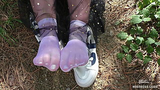 Cute Soles And Toes Wiggling In White Nylon Socks In The Forest