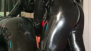 Intermediate Pegging: Two Latex Doms and the Brown Strap-on